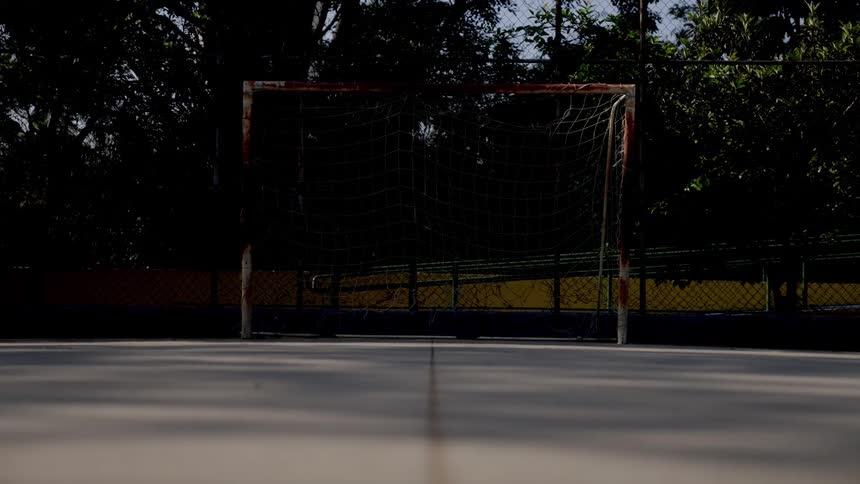 A netted goalpost in an outdoor soccer play area during daytime