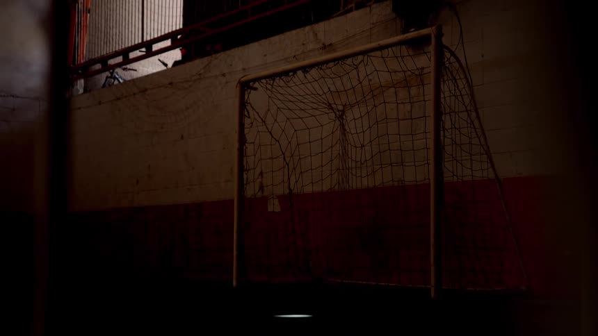 A netted goalpost in an soccer play area during daytime