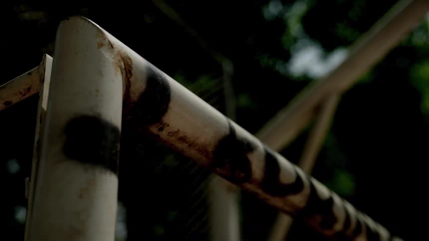 Close up of the corner frame of a metal goalpost struck by a soccer ball in a soccer play venue