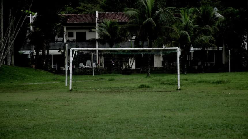 A netted goalpost on an outdoor soccer field during daytime