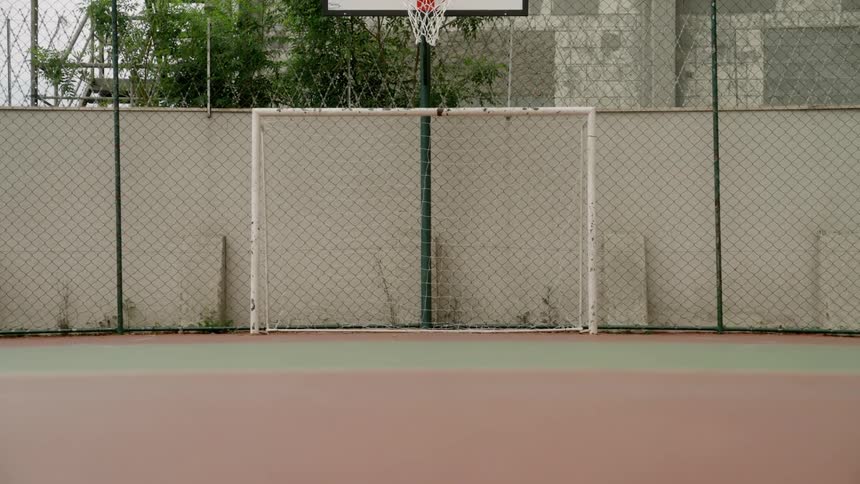 An empty court with a small square net placed in front of a basketball standard