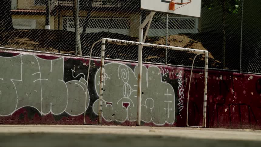 Outdoor basketball court with graffiti on the walls