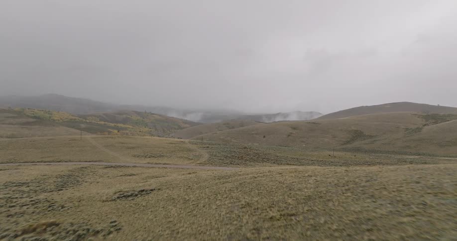 The green hills are covered in thick fog