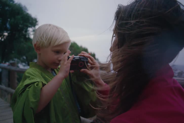 Son is taking a photo of his mother