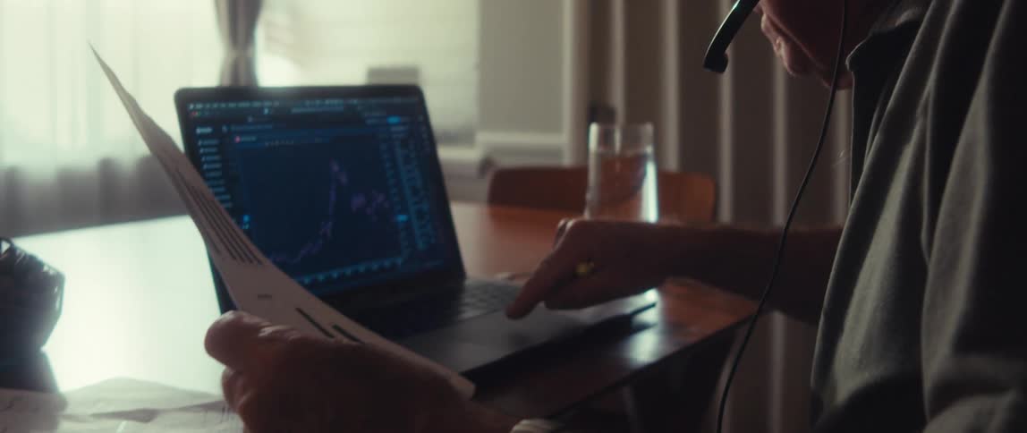 Man with headphones trading stock market on laptop