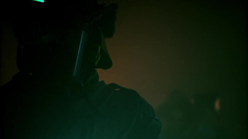 Firefighter in mask in a room at night with fire