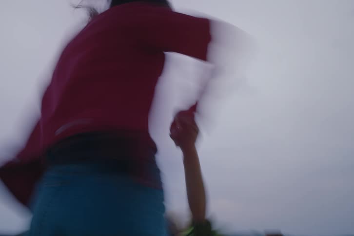 A mother is swinging her son around on the mountain top