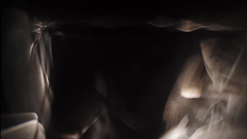 Light appears from behind a wavy dark object causing blurriness and glare
