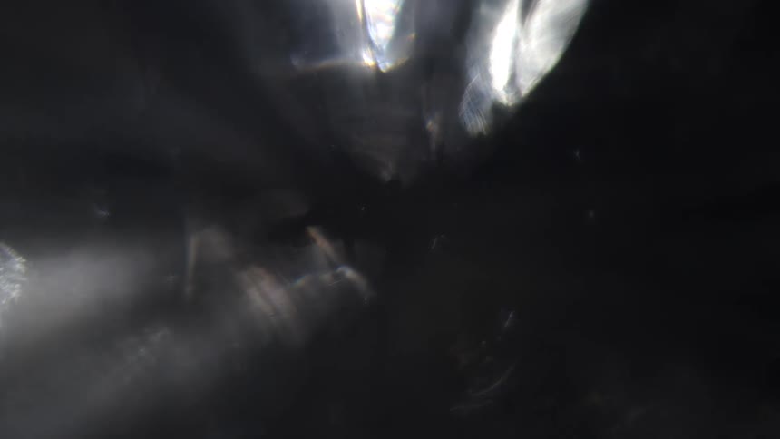 Beams of light pierce through a dark hazy space creating a textured visual effect