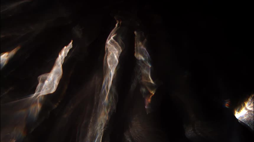 The image shows abstract light streaks and reflections against a dark background