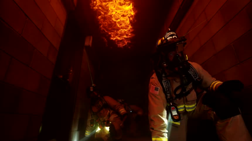 Firefighters in a burning building use lasers on their helmets to light their way