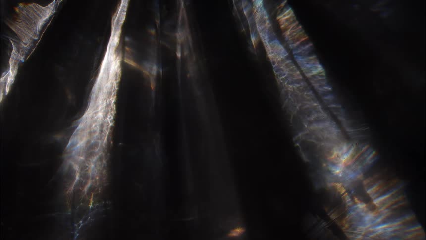 Reflections from unseen water casting light on the walls of a cave