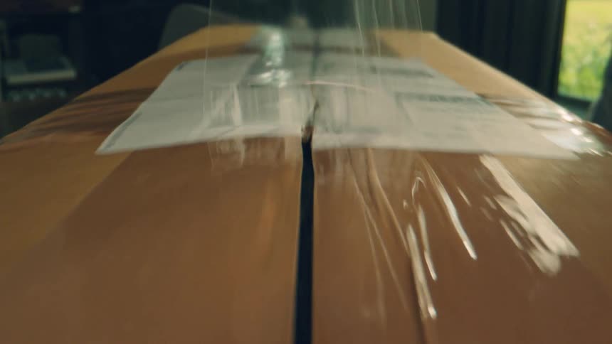 Close up of a woman unboxing a package indoors during daytime