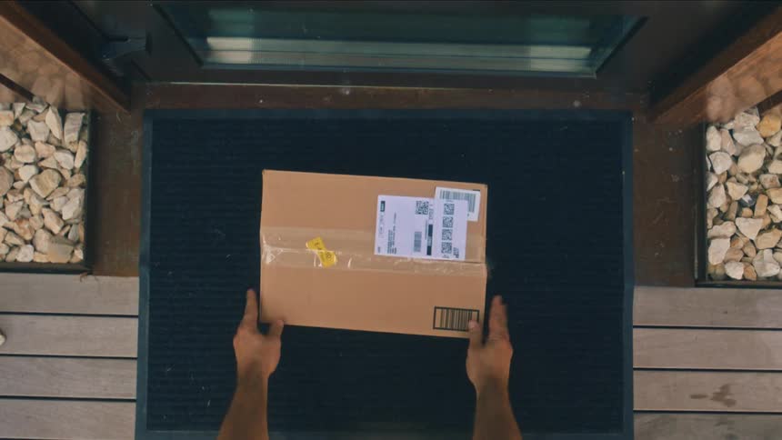 Delivery driver placing package on mat at front door