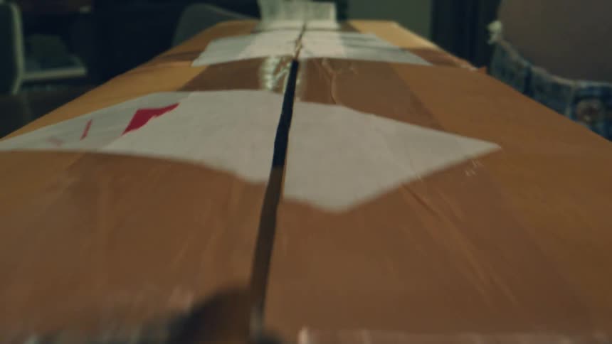 Person removing tape from a delivery box