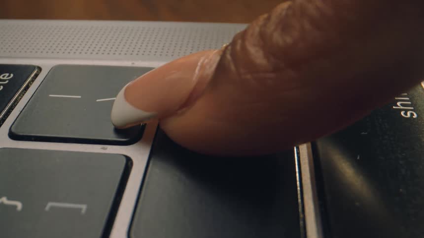 The woman reaches over and presses the enter key