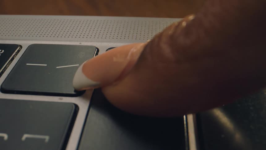 A woman presses he enter key on her laptop