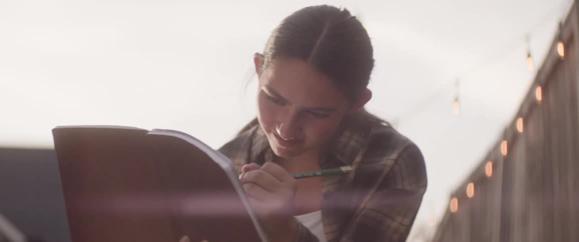 She uses a pencil to draw in her notebook