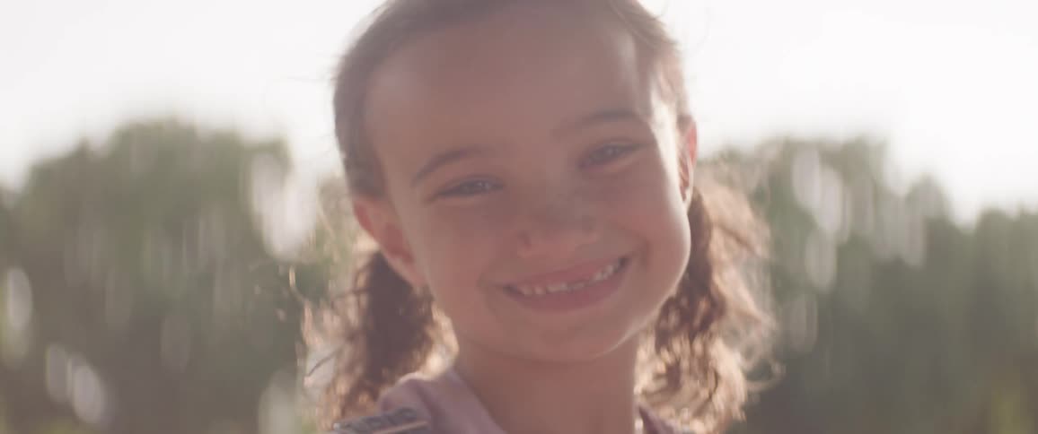 A girl has a big smile on a sunny day