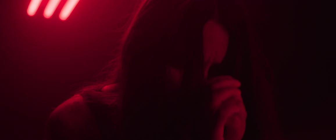 The woman is crying under the red light