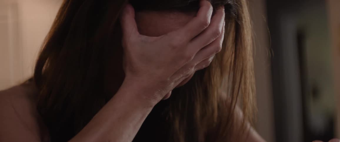 A woman begins sobbing and holds her face
