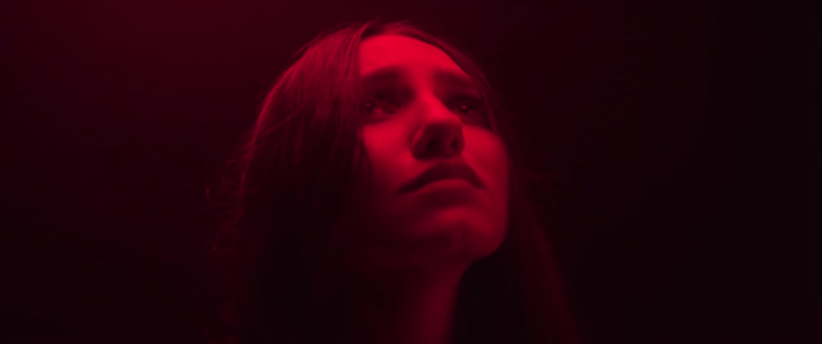 A girl is looking up into the red light