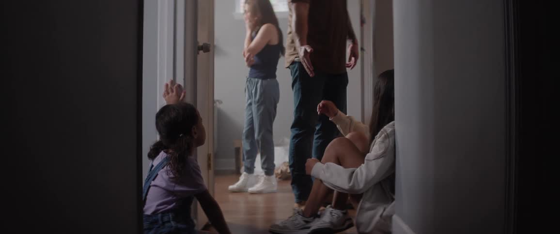 Parents worriedly have a discussion before father helps the teenager stand up to walk to another room