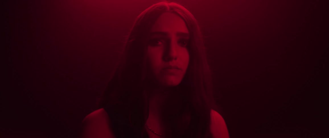 Girl looks up afraid in the dark room