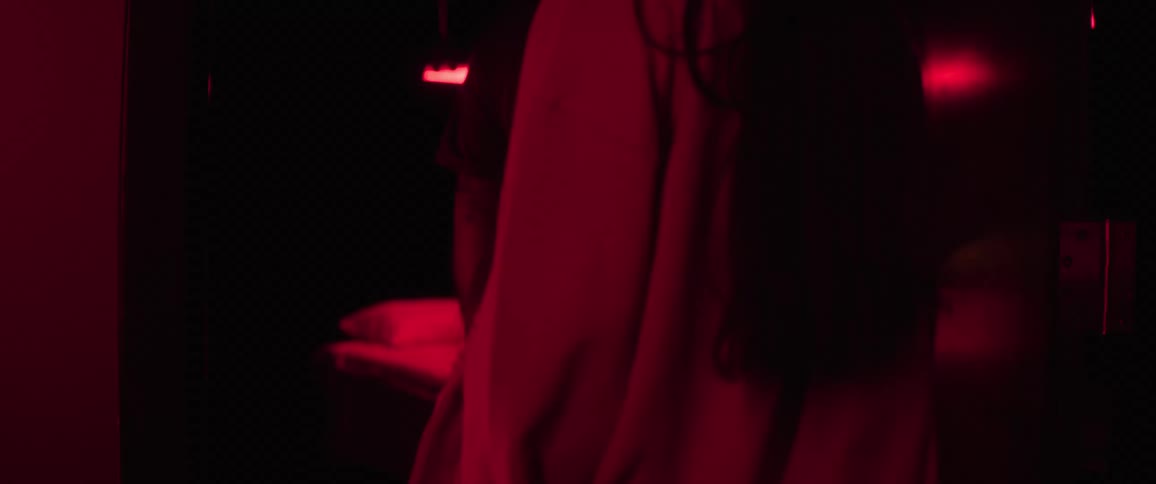 Two people entering a dimly lit room