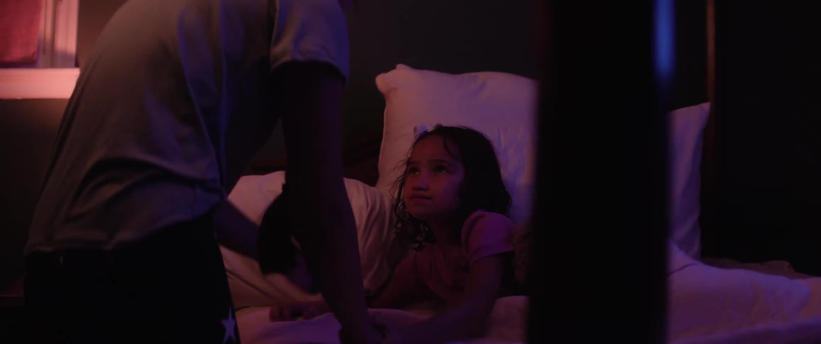 A father is tucking his daughter into bed and shakes her hand