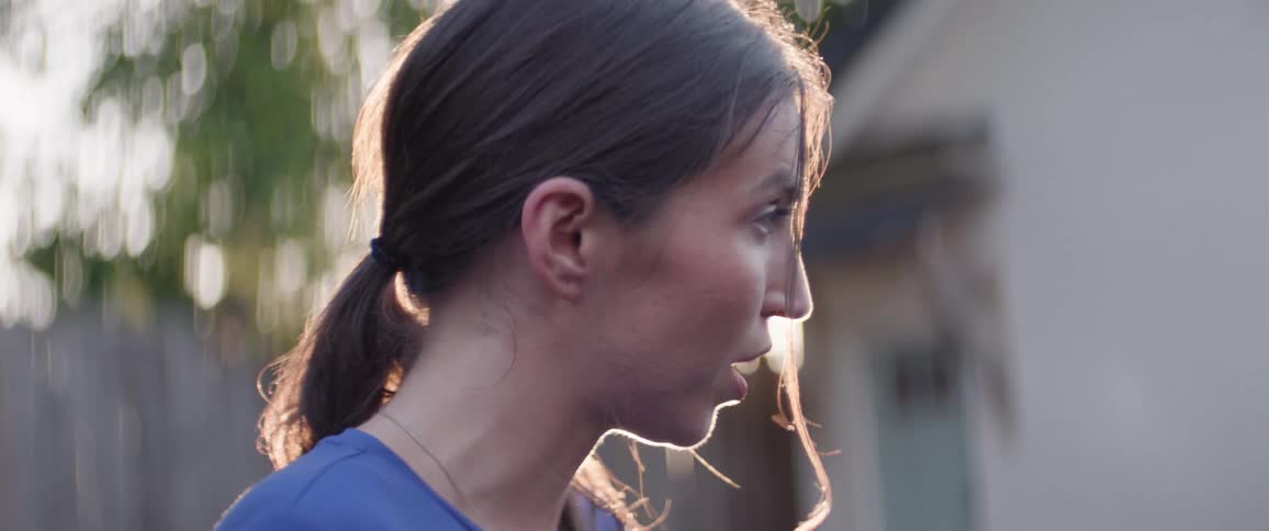 Close up portrait of a female teenager speaking while standing outdoors during daytime