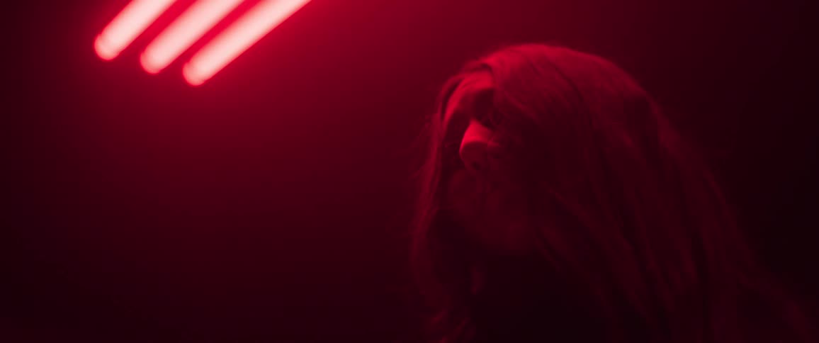 A woman looks sad under a red light