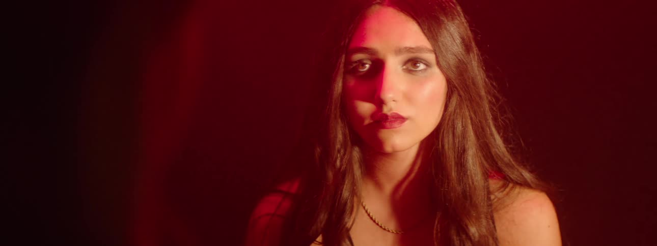 A girl is facing someone under the red light