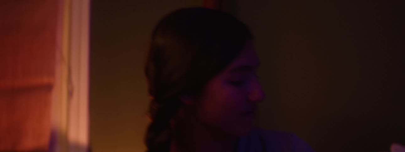 A teen sits in bed with her little sister and reads her a bedtime story
