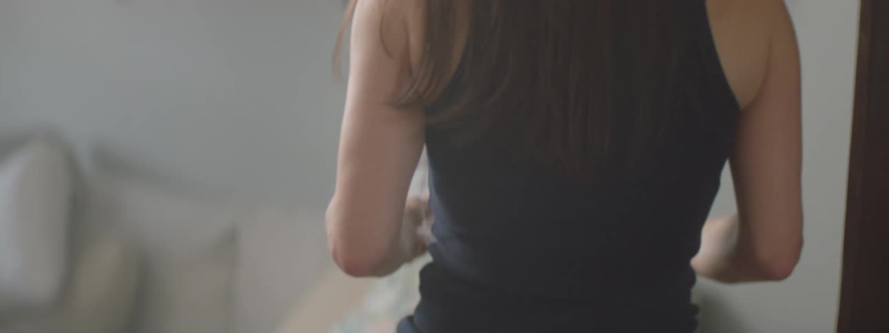 Woman walking through room of house holding letters