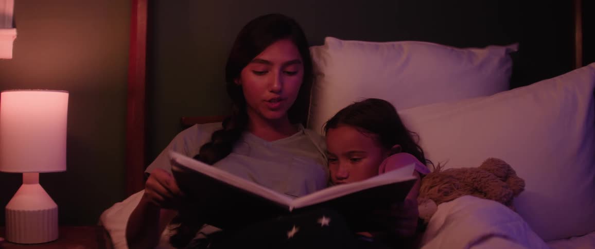 A mother is reading a bedtime story to her daughter
