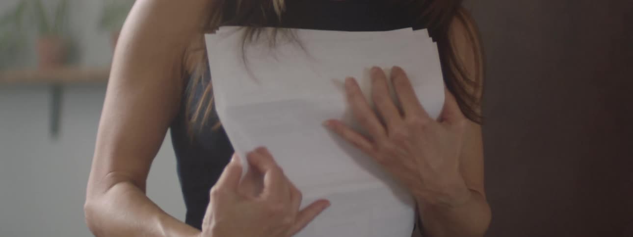 A woman is holding papers and walking