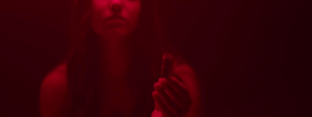 Woman burning sage in a dimly lit room