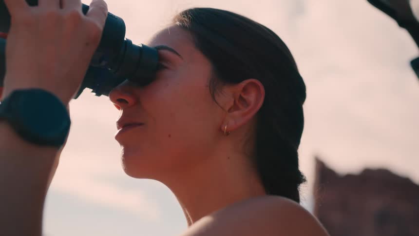 Woman in an outdoor environment using binoculars