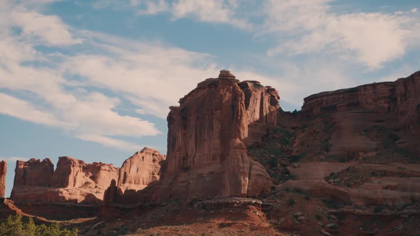 Clouds float over a mountain range that has eroded into canyons