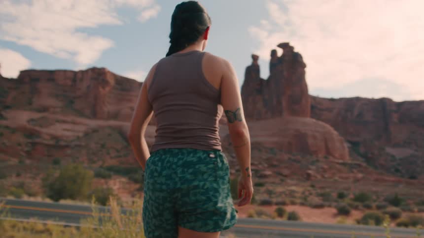 Woman ties her shoelaces and then takes in the mountains in front of her