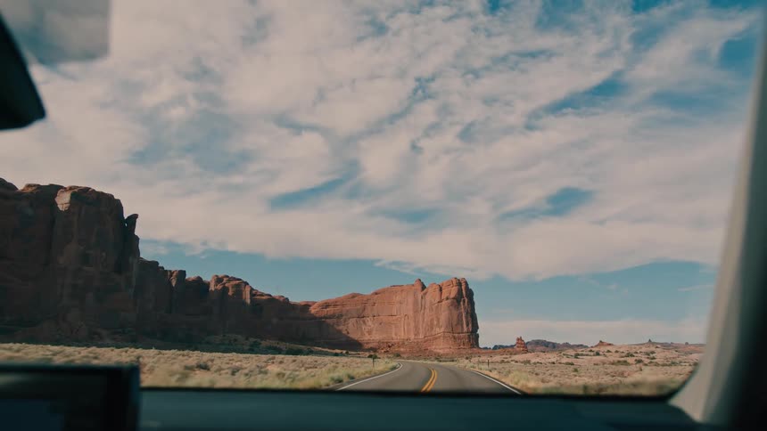 The car drives on the road towards the canyon