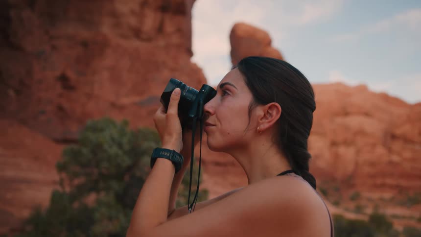 Female taking a picture of the canyons with a digital single lense camera