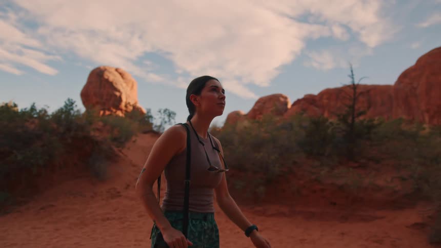 A woman is hiking on a path in the mountains