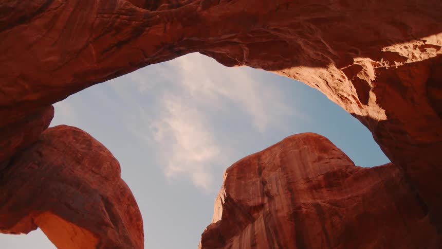 A group of people hike through a canyon at midday