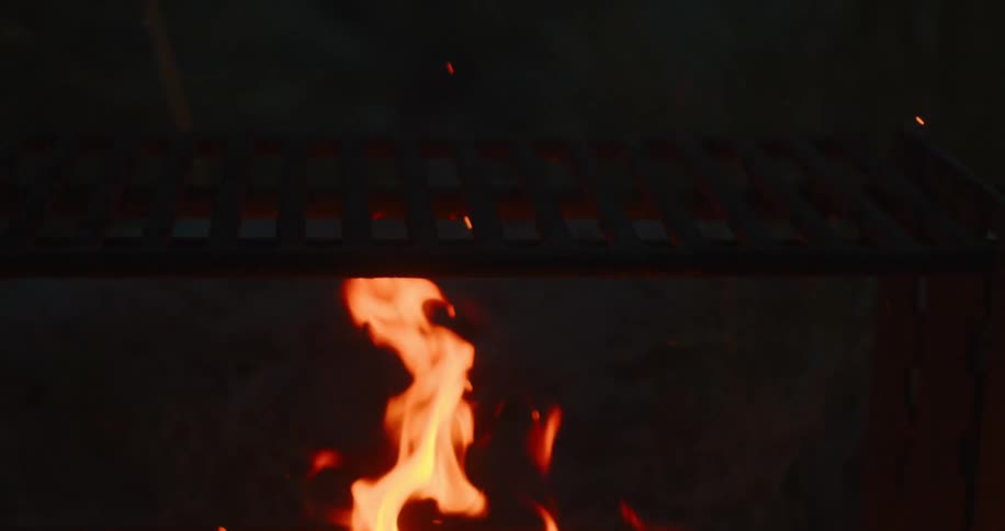 At a campsite a bonfire is burning during the night