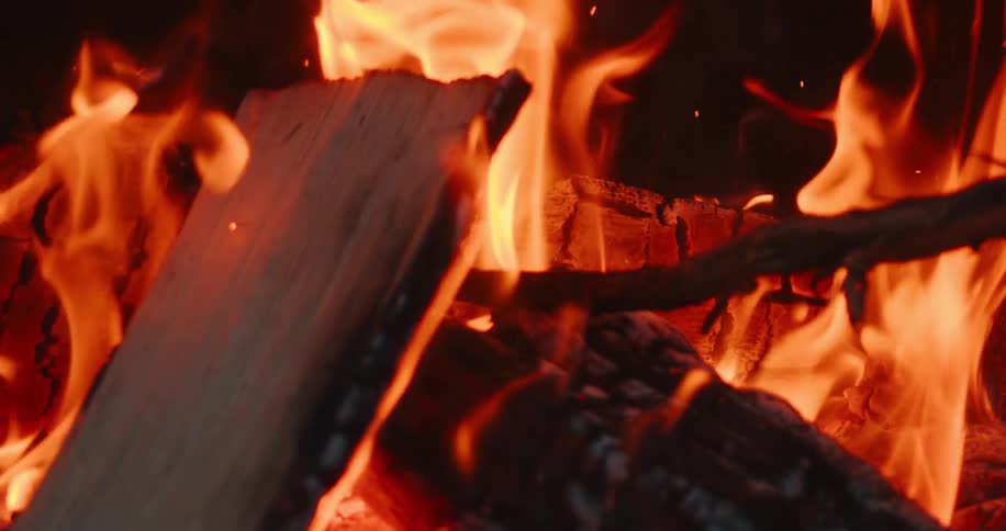 Sticks and tree logs are burning in the outdoor bonfire