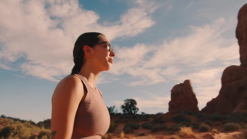 A woman is hiking on a path in the desert mountains
