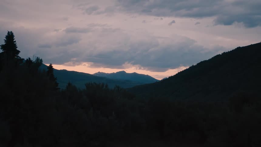 Sun is setting in the horizon of the calm wooded landscape