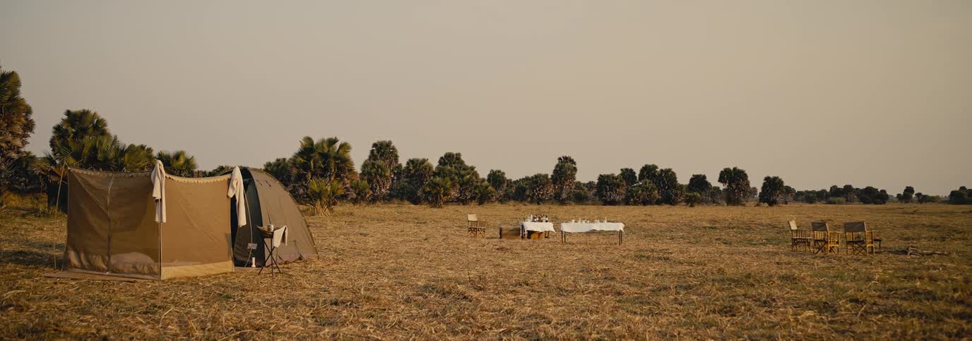 A tent and table are on the grass field